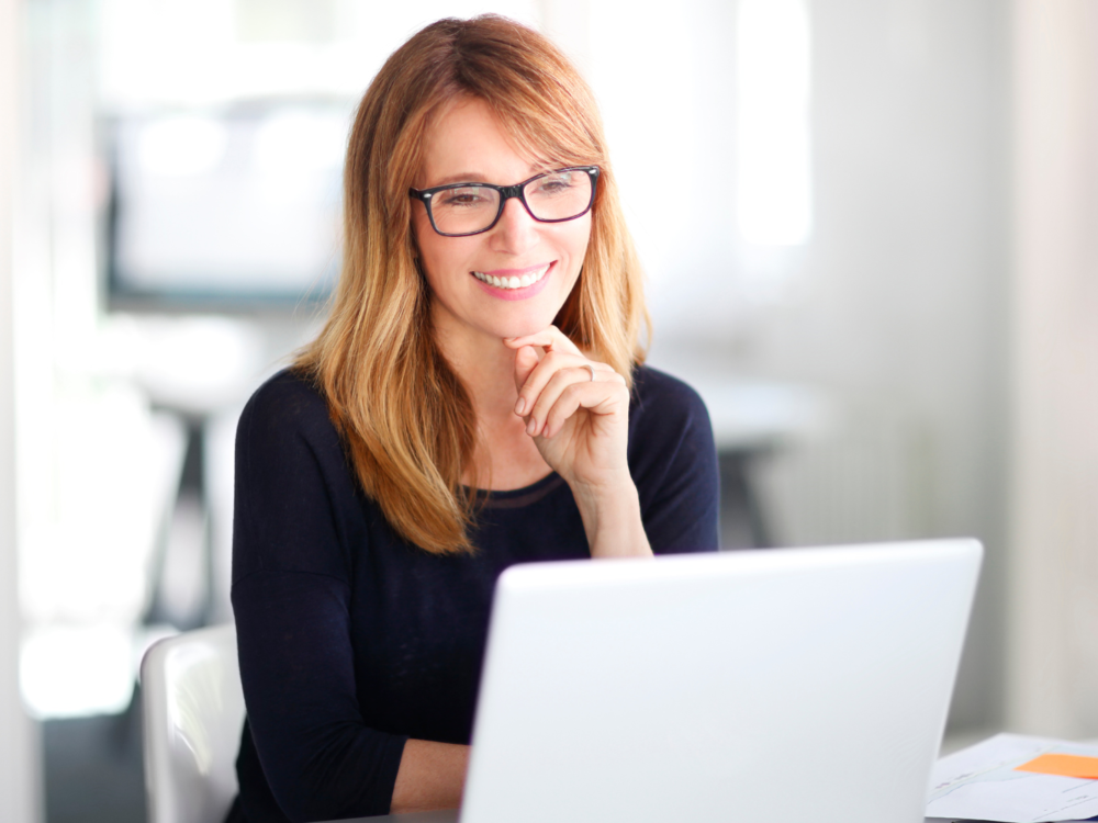 woman looking at her laptop smiling