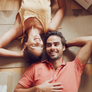 happy couple lying on the floor surrounded by boxes