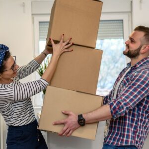 a man and woman moving house, holding boxes