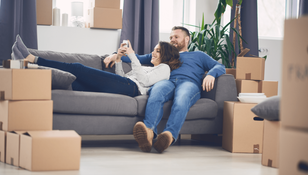 Happy couple lying on the sofa in their new home