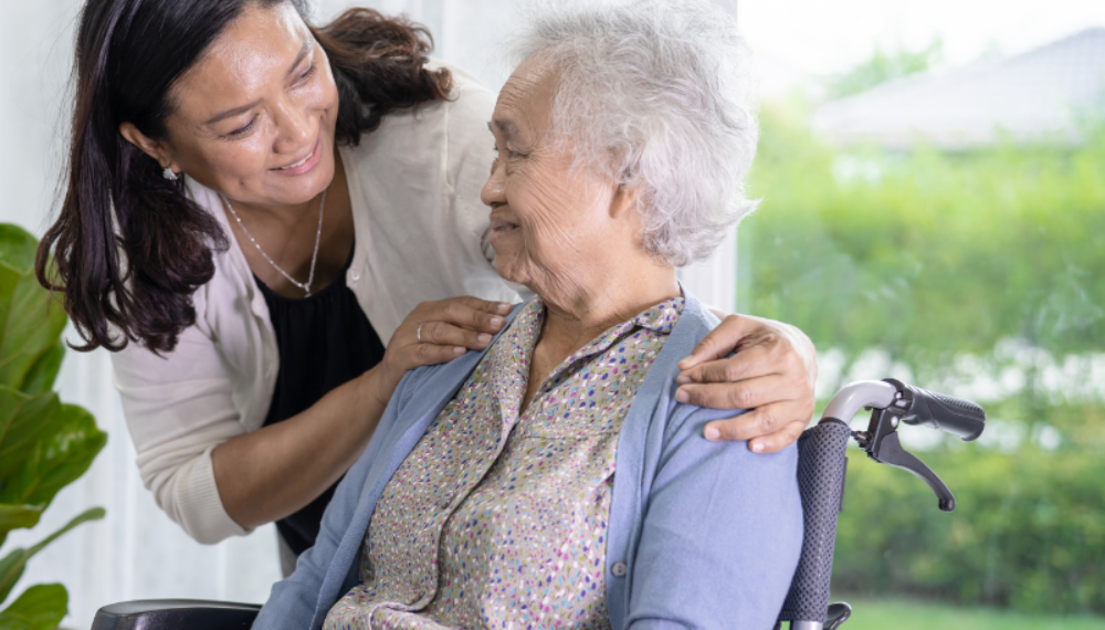 Adult daughter supporting her elderly mother in a wheelchair, symbolising the emotional and practical responsibilities of estate planning and executor duties.