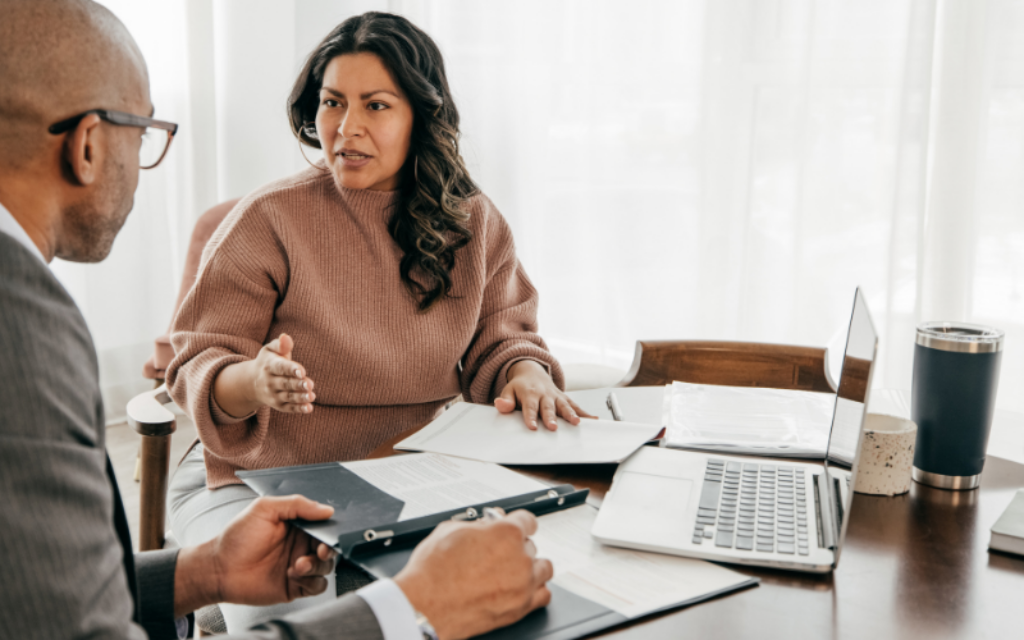 Professional woman discussing financial planning with an adviser, reviewing documents related to inheritance tax and estate strategy