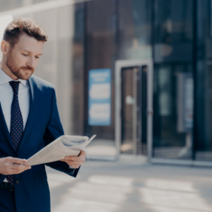 Confident barrister in a sharp blue suit reading about offset mortgages.
