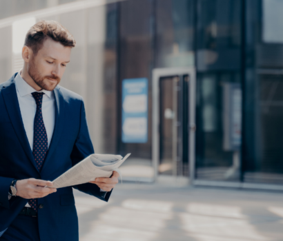 Confident barrister in a sharp blue suit reading about offset mortgages.